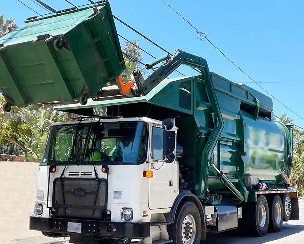 A garbage truck is parked on the side of the road.