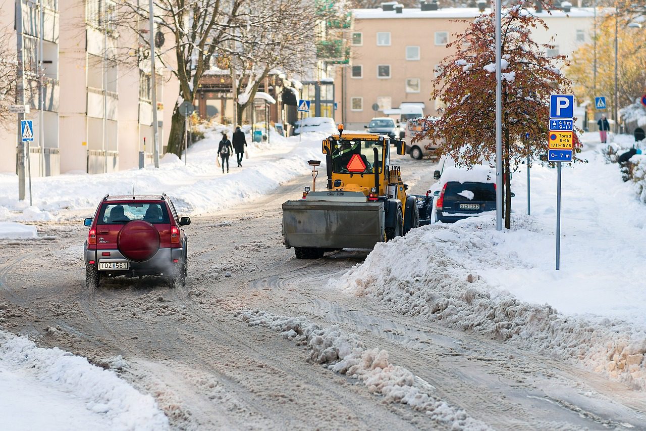 A snow plow is parked on the side of a road.