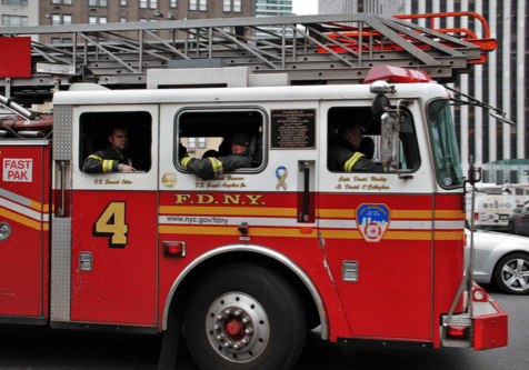 A fire truck with two firefighters in the window.